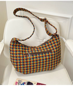 Close-up of a multicolor checkered tweed dumpling bag with visible woven texture and zipper
