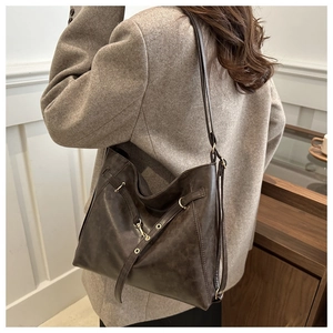 Detailansicht einer braunen Vintage Leder-Hobo-Tasche mit Metallösen und Riemen für Damen