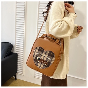 Side view of a vintage brown leather backpack featuring a heart plaid puppy design