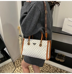 Detail view of stylish checkered tote bag with wide vintage patterned shoulder strap