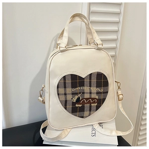 Close-up of heart-shaped plaid cutout with cartoon dog embroidery on a white PU backpack