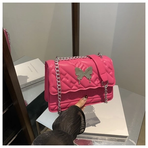 Détail du sac à bandoulière matelassé rose rouge avec fermoir papillon argenté