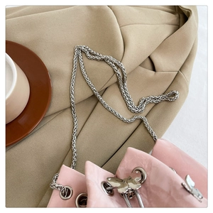 Vue détaillée du sac à cordon rose avec breloque papillon argentée et chaîne