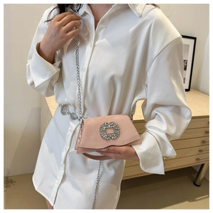 Detailed close-up of pink suede crossbody bag featuring a sparkling crystal buckle and silver chain