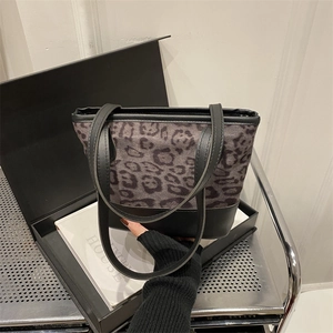 Fashionable leopard print tote bag with black leather handles in a luxury gift box setting