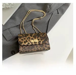 Detail shot of leopard print crossbody bag with gold chain strap and smartphone for size scale