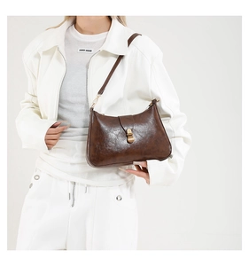 Gros plan sur un sac croissant marron vintage en cuir avec fermoir doré