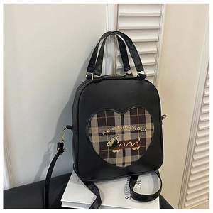 Detailed close-up of retro black faux leather backpack with heart-shaped window and cartoon puppy