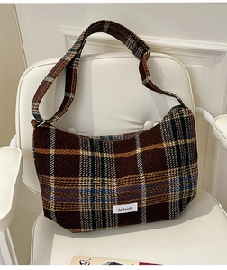 Close-up of brown plaid fabric texture and retro checkered pattern on a crossbody bag