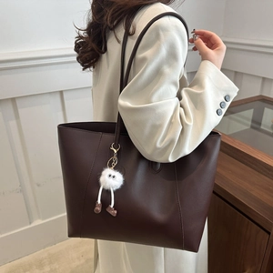 Minimalist deep brown leather tote bag for women with a cute white plush pendant