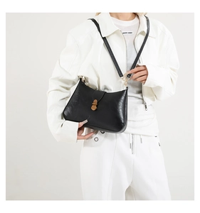 Détail du sac à main minimaliste en cuir noir mat avec boucle en métal doré vintage