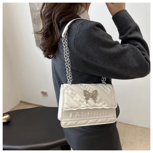 Détail du sac bandoulière blanc en similicuir matelassé avec fermoir papillon argenté