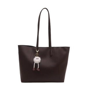 Brown leather tote bag with long straps and cute white plush charm on white background