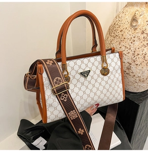 Detailed close-up of jacquard tote bag with brown leather handles and chic patterned strap