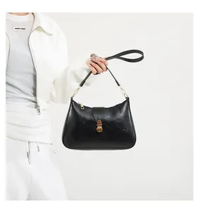 Détail du sac croissant rétro noir avec fermeture éclair dorée et boucle métallique chic