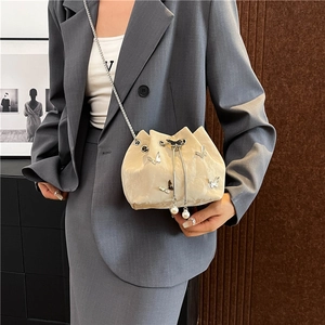 Sac seau en velours crème élégant avec breloques papillon argentées et chaîne perle