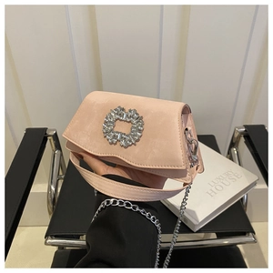 Close-up of pink suede crossbody bag featuring a luxury square rhinestone buckle and silver chain
