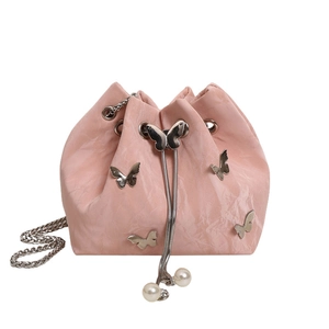 Sac seau rose à cordon avec plis, breloques papillon argentées et chaîne en perles