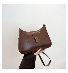 Détails du sac croissant marron vintage avec texture et boucle en métal doré