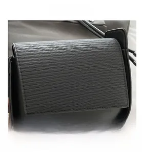 Close-up detail of the horizontal embossed texture on a black crossbody bag's flap