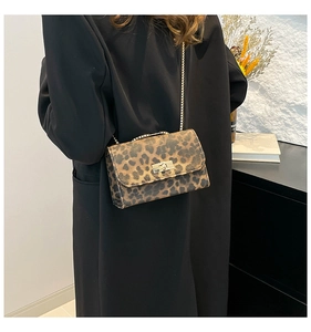 Fashionable leopard print crossbody bag with gold chain strap shown on black blazer