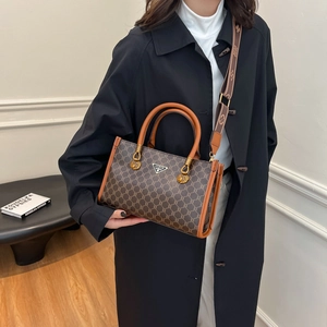 Brown monogram tote bag with leather handles and an adjustable patterned shoulder strap