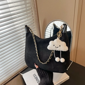 Chic black faux suede tote bag with chain strap and cute cloud charm in home setting
