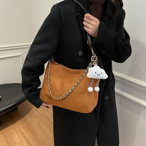 Brown faux suede half-moon shoulder bag with chain strap and plush smiley charm