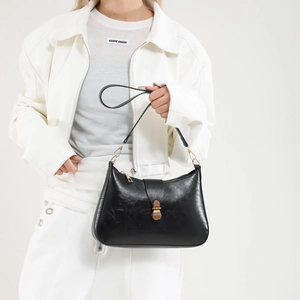 Sac hobo croissant noir rétro français avec fermoir doré porté par un mannequin