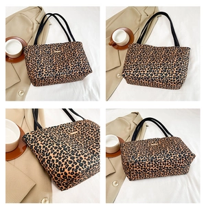 Detail view of leopard print tote bag featuring fabric texture and black handles