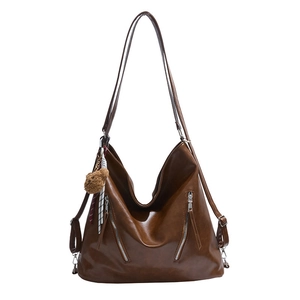 Brown soft leather hobo bag with dual silver zippers and plush bear charm decoration