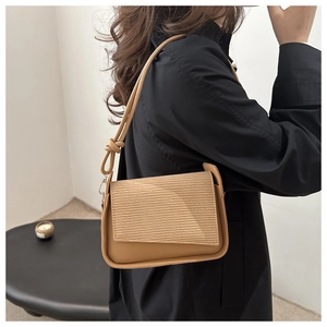 Detail of camel brown crossbody bag showing corduroy texture and knot strap design