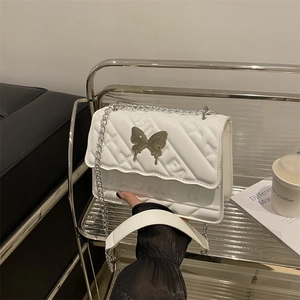 Sac bandoulière blanc matelassé avec boucle papillon argentée et bandoulière en chaîne