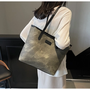 Model view of large canvas tote bag in olive green with black leather shoulder straps