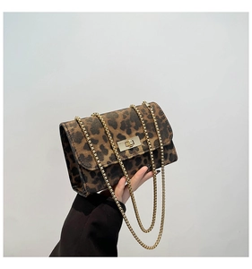 Close-up of leopard print crossbody bag featuring gold chain and turn-lock closure