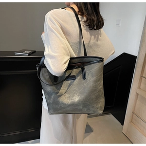Detailed view of gray large capacity tote bag with logo patch shown on model