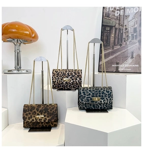 Detailed view of three leopard print crossbody bags with elegant gold metal chain straps