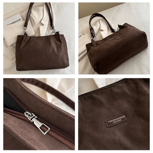 Detail of dark brown suede tote bag featuring silver chain straps and a leather logo patch