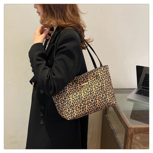 Detail showing high-quality leopard print texture and golden logo on large tote bag