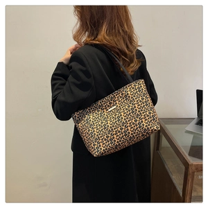 Detail of the leopard print tote bag with a metallic logo plate on black canvas