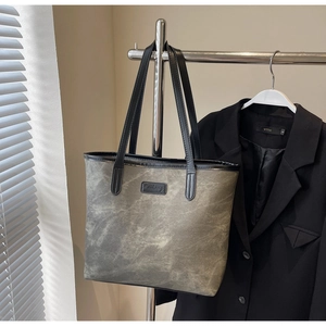 Detail view of washed canvas tote bag with black leather trim and vintage texture finish