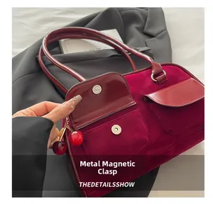Detailed macro view showing the metal magnetic buckle and velvet texture of the handbag