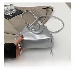 Detailed macro view of the wear-resistant rectangular base on a silver bucket bag