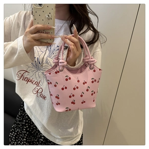 Detailed shot of pink cherry print tote bag with unique knotted handle and silver rings