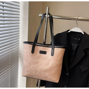Detail of pink large tote bag hanging on silver rod with elegant brand logo display