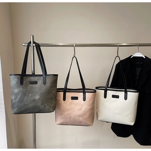 Three minimalist large capacity tote bags in grey, pink, and white with black straps