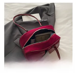 Detail view of red faux suede bag interior showing capacity for phone and wallet