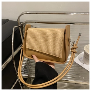 Detail showing the brown pleated woven flap and smooth texture of the women crossbody bag