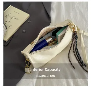 Internal capacity of the white cylinder shoulder bag showing space for phone and makeup