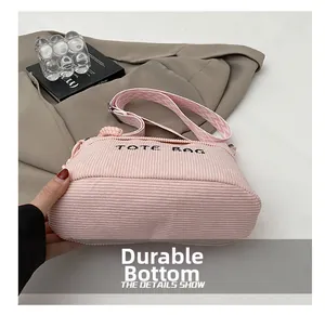 Detail of pink corduroy tote bag showing the durable base and woven shoulder strap
